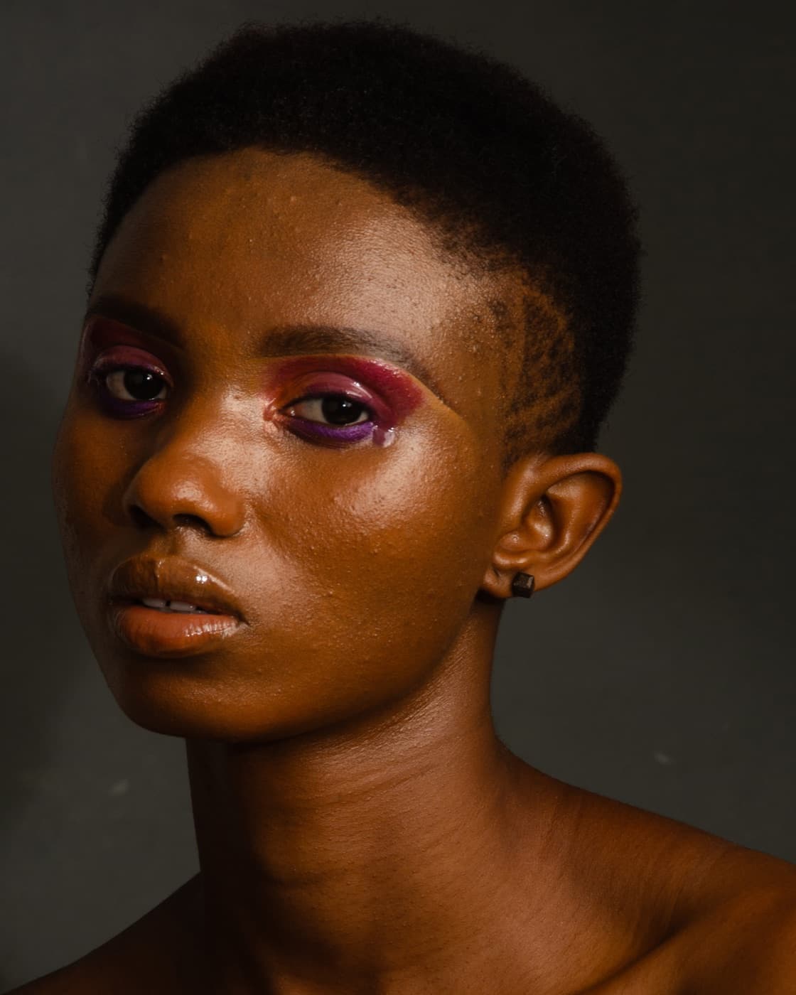 Portrait beauté avant retouche : fond gris, peau brillante, maquillage terne